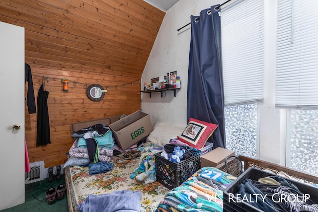 bedroom featuring lofted ceiling, carpet, visible vents, and wooden walls