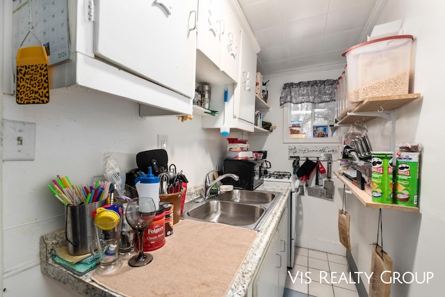 kitchen with open shelves, a sink, light countertops, and white cabinets