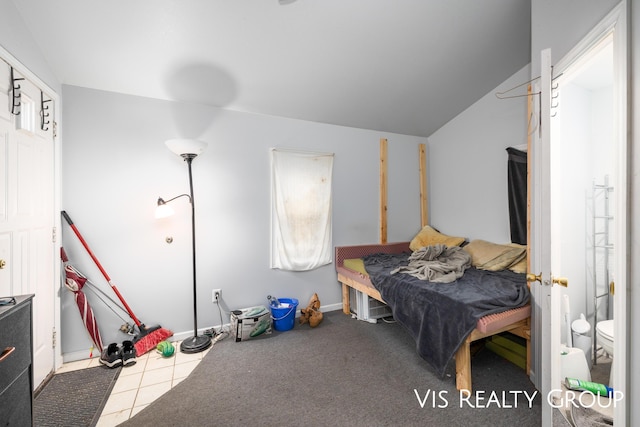 bedroom with lofted ceiling and tile patterned floors