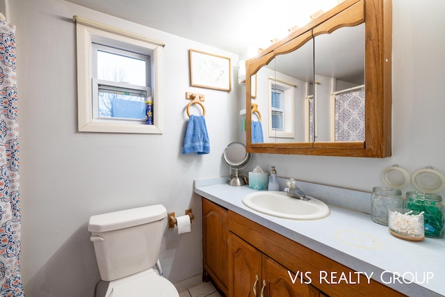 bathroom featuring a shower with curtain, vanity, and toilet