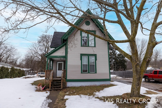 view of front of home featuring a shingled roof and fence