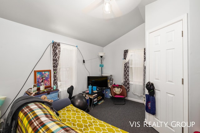 carpeted bedroom with vaulted ceiling and a ceiling fan