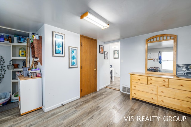 interior space with visible vents, baseboards, and wood finished floors