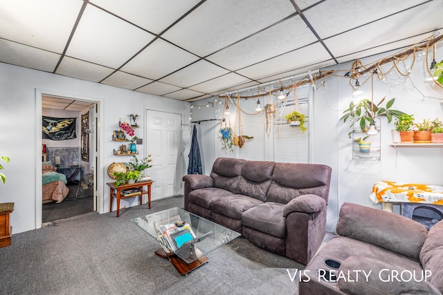 living area featuring carpet flooring and a paneled ceiling