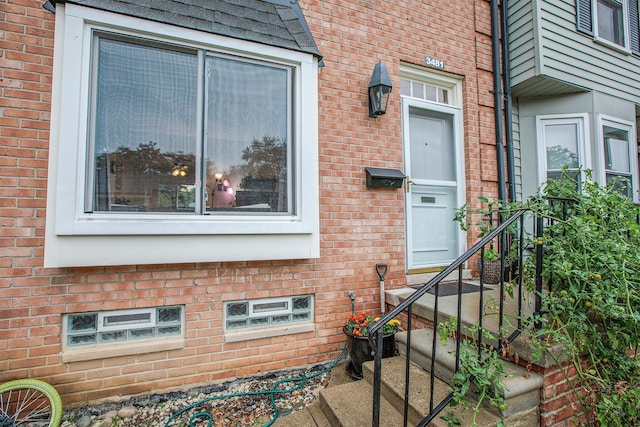 view of exterior entry with brick siding