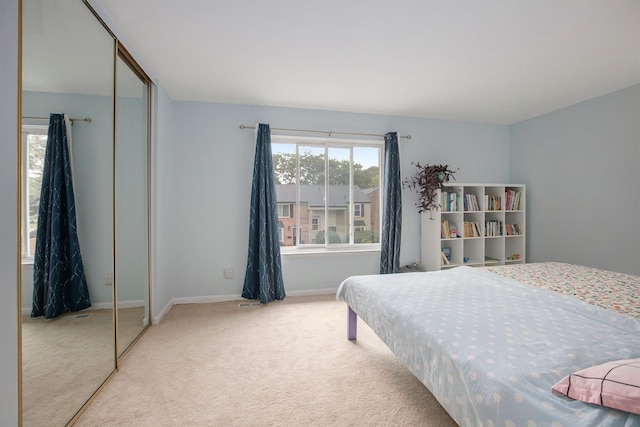 bedroom with carpet floors, baseboards, and a closet