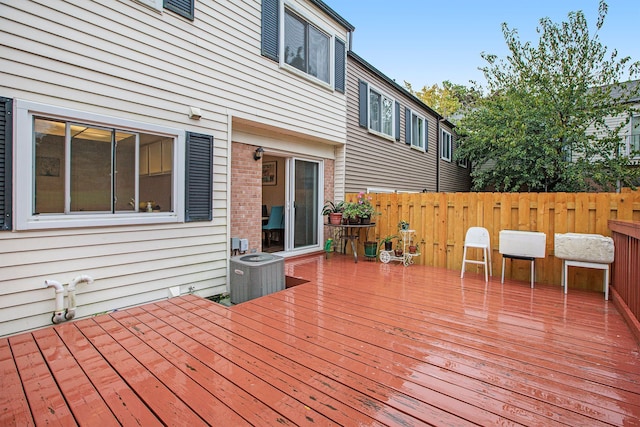 wooden deck featuring cooling unit and fence