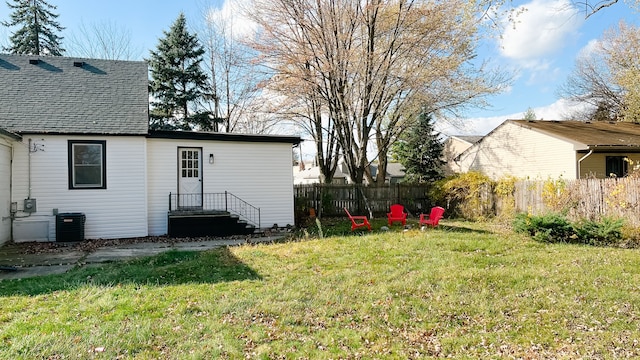 view of yard featuring fence and central AC