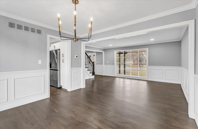 unfurnished room with visible vents, dark wood finished floors, stairway, crown molding, and a chandelier