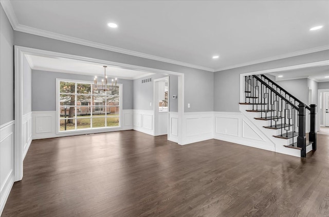 interior space with dark wood finished floors, a notable chandelier, recessed lighting, ornamental molding, and stairs