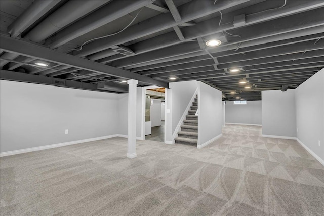 below grade area with carpet floors, stairway, and baseboards