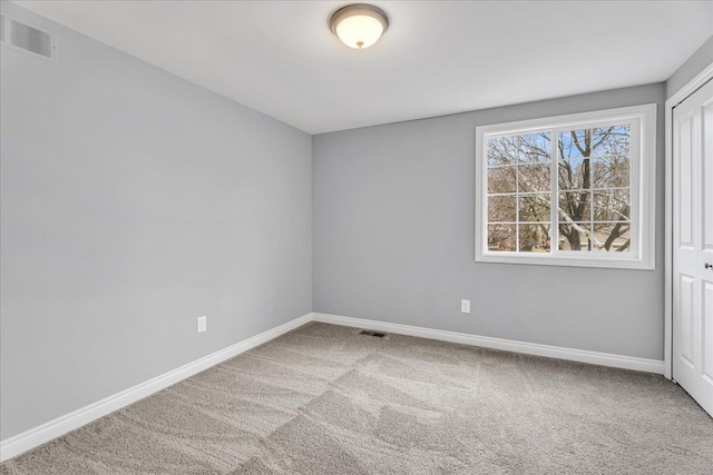 carpeted empty room featuring visible vents and baseboards