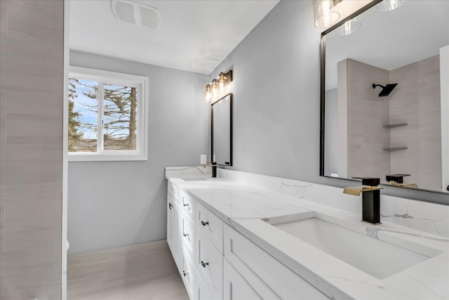 bathroom with double vanity, visible vents, a shower, and a sink