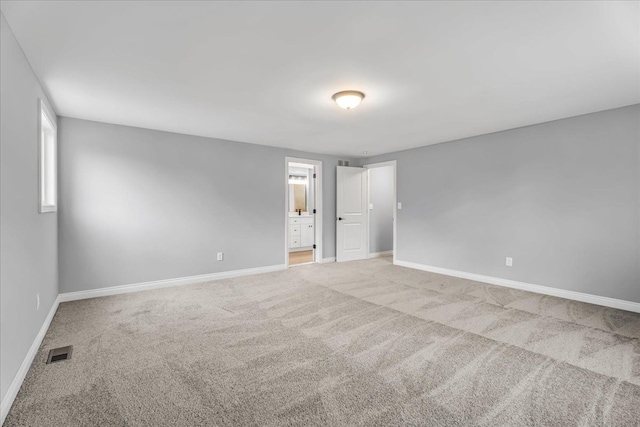 carpeted empty room with visible vents and baseboards