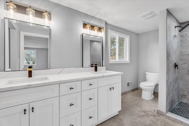 full bath featuring a stall shower, a sink, toilet, and double vanity