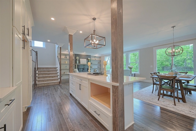 kitchen featuring a chandelier, dark wood finished floors, white cabinetry, and pendant lighting