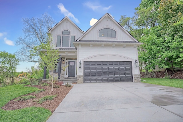 view of front of property featuring driveway, stone siding, and a garage