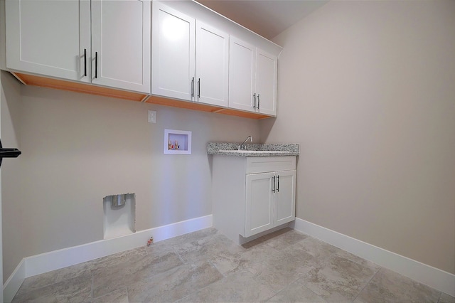 laundry area featuring washer hookup, cabinet space, and baseboards