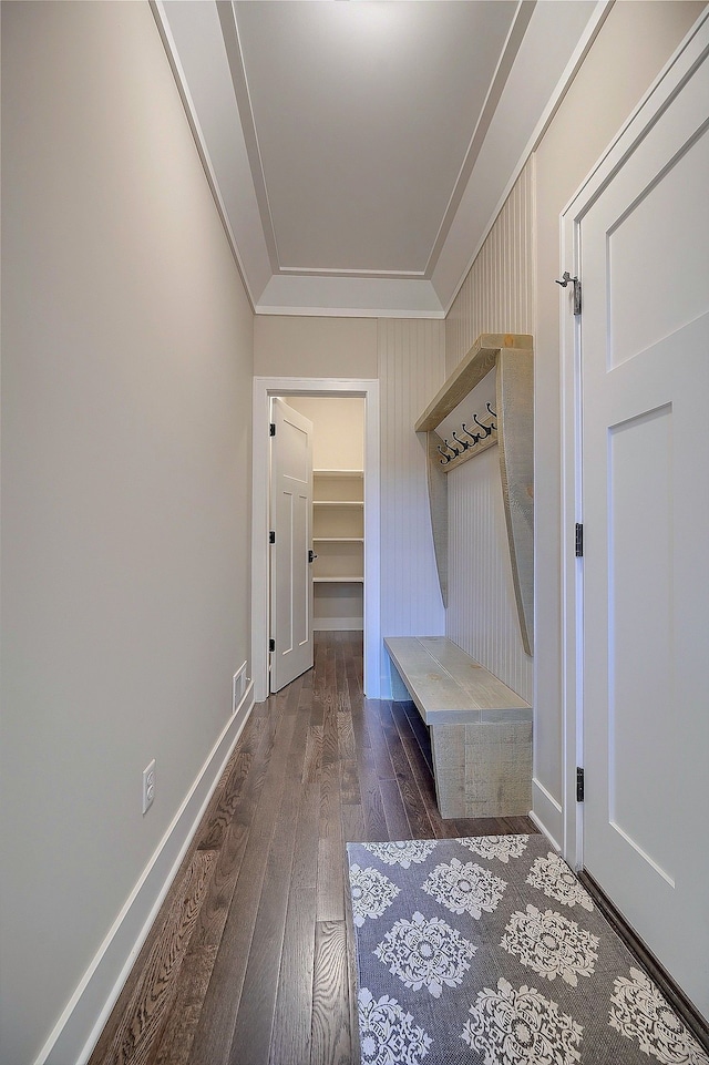 mudroom with dark wood-type flooring, visible vents, crown molding, and baseboards