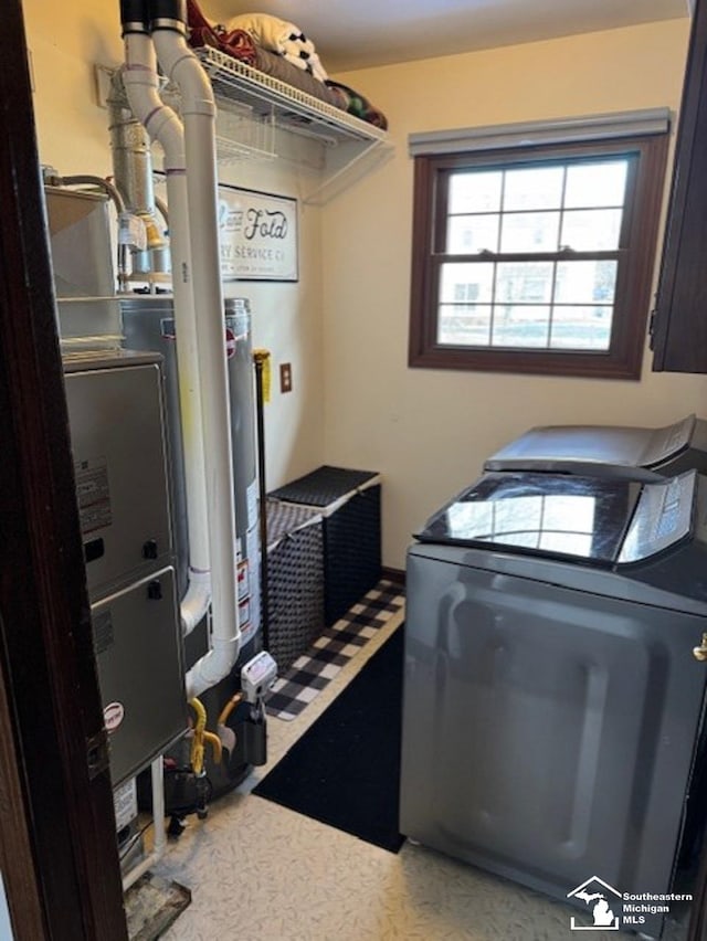 laundry area with laundry area, water heater, and washer and clothes dryer