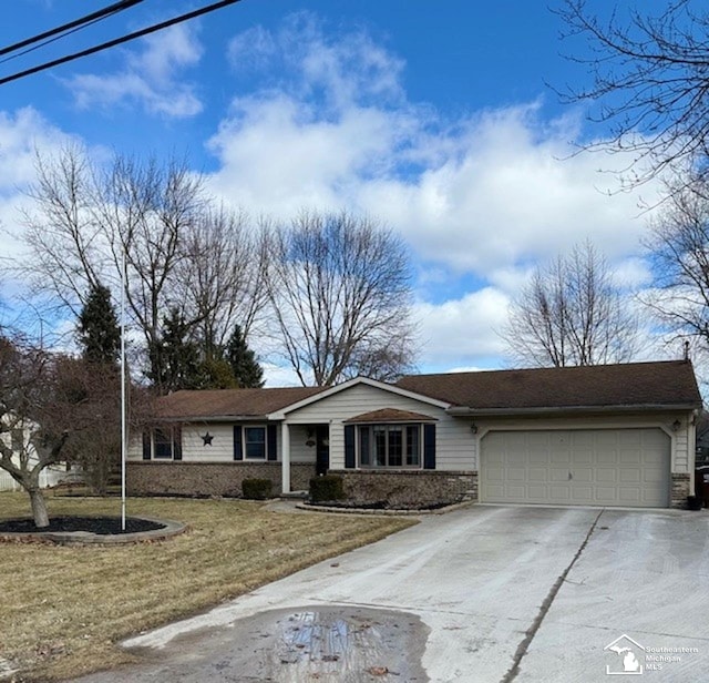 ranch-style home with concrete driveway, a front lawn, and an attached garage