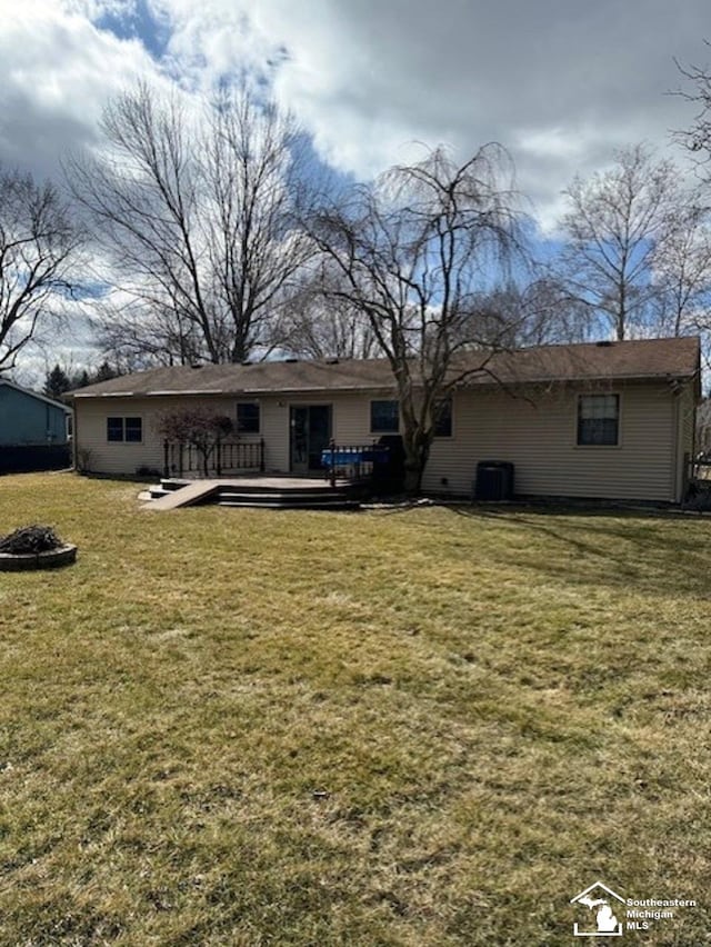 back of property featuring central AC unit, a lawn, and a wooden deck