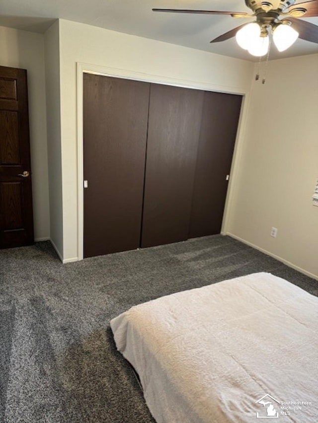 bedroom featuring a closet, dark carpet, a ceiling fan, and baseboards