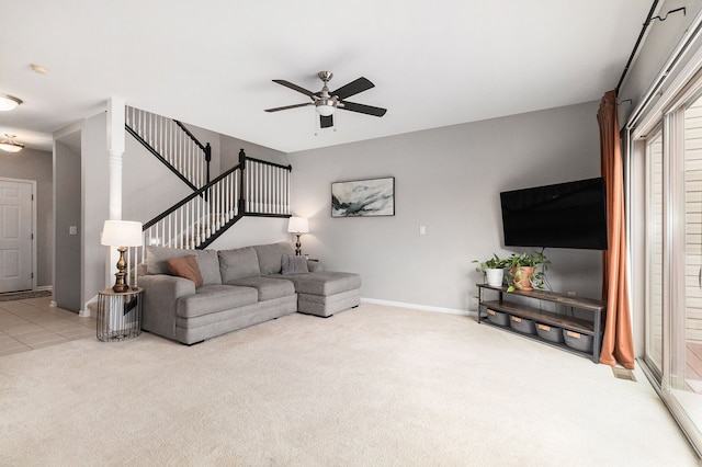 living room featuring a ceiling fan, baseboards, stairway, and carpet flooring