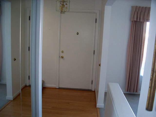 corridor featuring light wood-style floors and baseboards