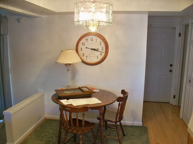 dining area featuring baseboards, a notable chandelier, and wood finished floors