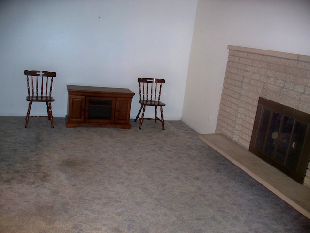 living area featuring light carpet and a brick fireplace