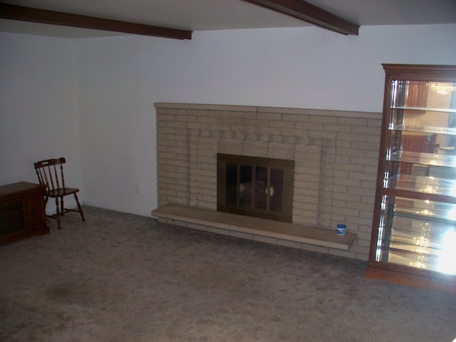 unfurnished living room featuring a brick fireplace, carpet, and beam ceiling