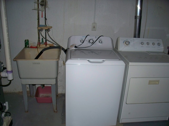 laundry area with laundry area, washer and clothes dryer, and a sink