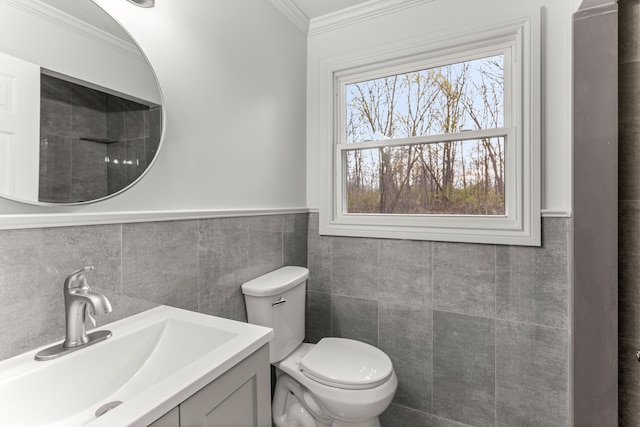 bathroom featuring tile walls, crown molding, vanity, and toilet