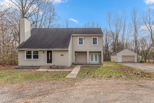 view of front of home featuring french doors, a detached garage, a chimney, and an outdoor structure