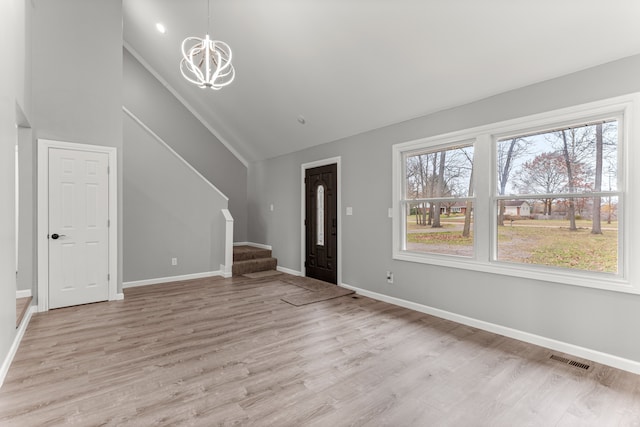 entryway featuring baseboards, visible vents, an inviting chandelier, stairs, and light wood-style floors