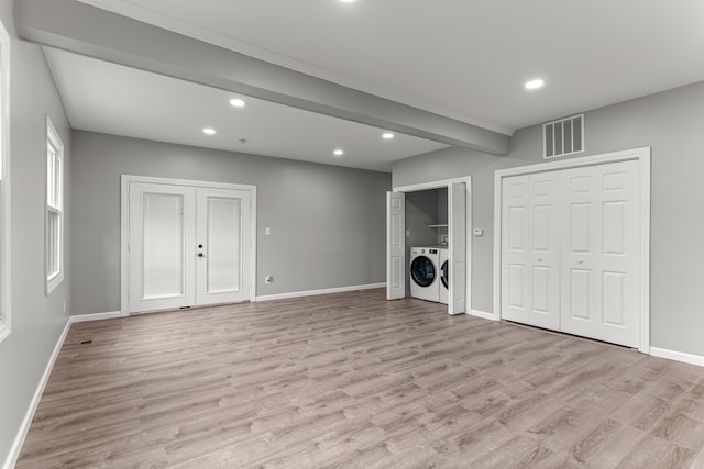 basement with light wood-style floors, washer and dryer, visible vents, and baseboards