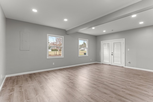 empty room featuring recessed lighting, beamed ceiling, light wood-type flooring, and baseboards