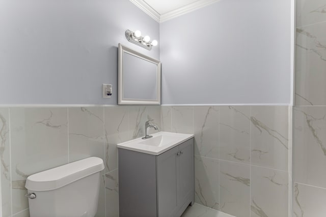 bathroom with toilet, tile walls, crown molding, and vanity