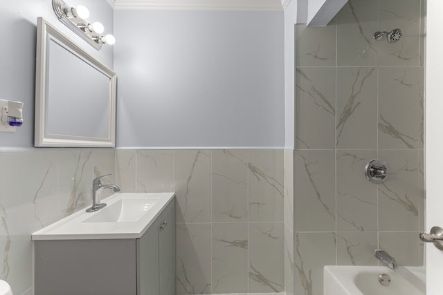 full bath with ornamental molding, tile walls, shower / bath combination, and vanity