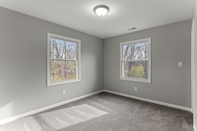 unfurnished room with carpet floors, baseboards, and visible vents