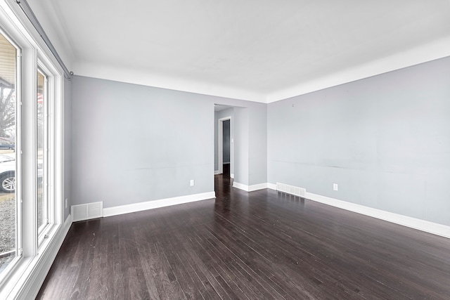 unfurnished room featuring visible vents, baseboards, and wood finished floors