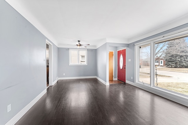 foyer entrance with dark wood finished floors, baseboards, and ceiling fan