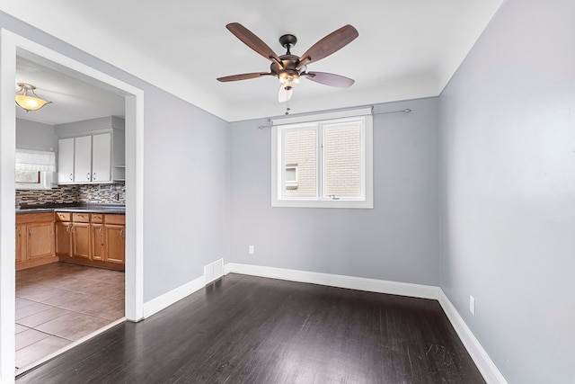 interior space featuring ceiling fan, baseboards, and wood finished floors