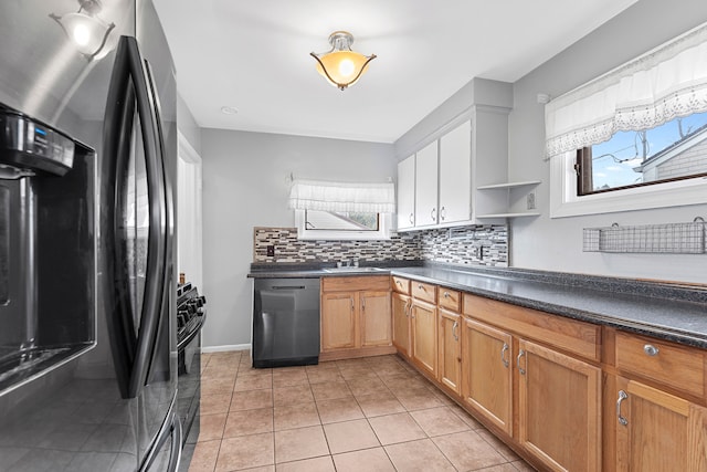 kitchen with dark countertops, a healthy amount of sunlight, dishwasher, and stainless steel fridge with ice dispenser