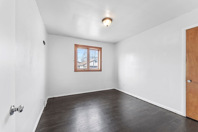 spare room with dark wood-style floors and baseboards