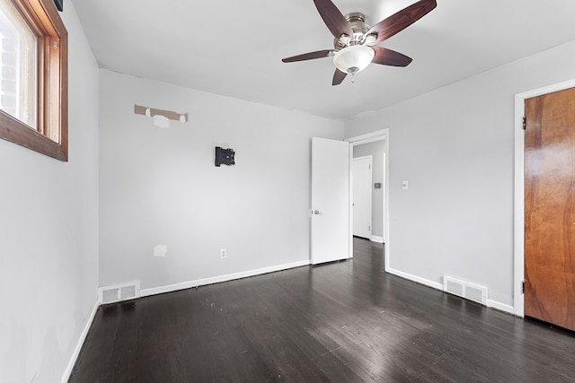 unfurnished bedroom featuring dark wood-style floors, visible vents, and baseboards