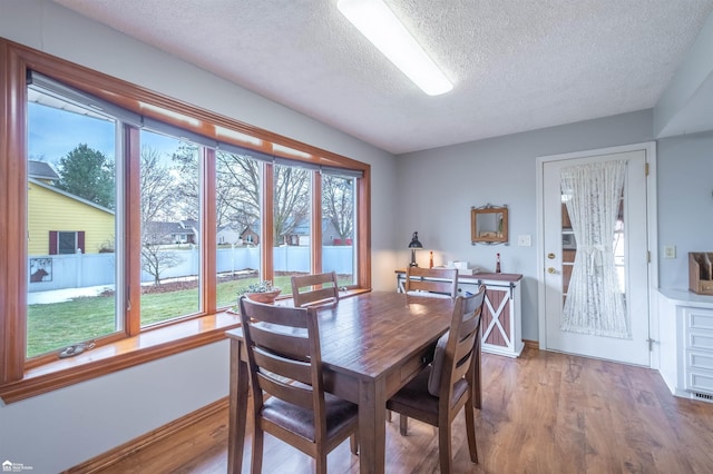 dining room featuring a textured ceiling and light wood finished floors