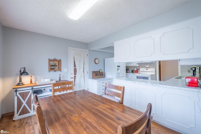 dining room with light wood-style floors and a textured ceiling