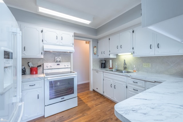 kitchen with white appliances, under cabinet range hood, white cabinetry, and a sink